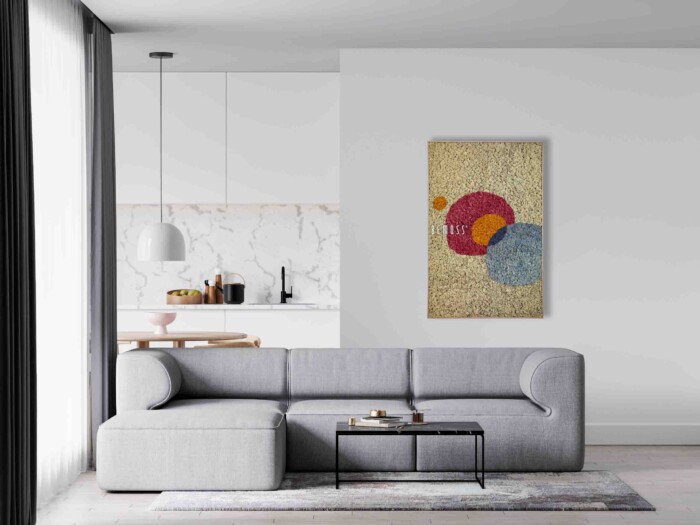 Minimalistische woonkamer met een moderne grijze sectionele bank en een zwarte salontafel. Aan de muur boven de bank hangt een Abstract Oleiros. Een BEMOSS moswand voegt een vleugje natuur toe aan de serene ruimte. De achtergrond toont een witte keuken met een marmeren achterwand en een hanglamp boven een aanrechtblad.