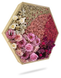 Een zeshoekig houten frame gevuld met een levendig, ingewikkeld arrangement van bewaarde bloemen. De bloemen, waaronder verschillende tinten roze, rood en crème, vormen een prachtig mozaïekachtig patroon. Het woord "BEMOSS" is zichtbaar aan de linkerkant van het frame en voegt een uniek tintje toe aan deze boeiende Mosschilderij PLANTEN Cupido.