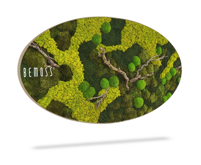 Deze ovale verticale wanddecoratie van BEMOSS, deze Mosschilderij BEMOSS® ORTHO TOCÓN heeft een levendig, driedimensionaal ontwerp van groen geconserveerd mos en korstmos met textuurpatronen die lijken op een bosdak. Het stuk werpt een lichte schaduw op de witte achtergrond.