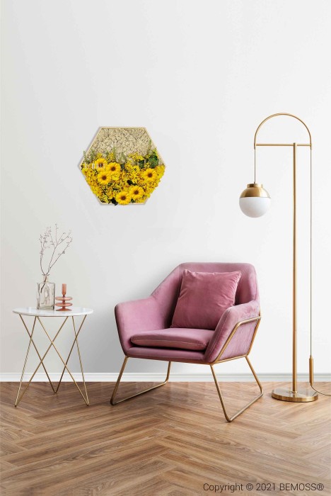 Een gezellige kamer met een roze fluwelen fauteuil met gouden poten, naast een bijzettafeltje met een gouden frame met daarop een plantje, decoratieve voorwerpen en een glazen fles. Hierboven hangt een BEMOSS mosschilderij met gele bloemen. Vlakbij staat een gouden vloerlamp met een witte bolvormige kap.