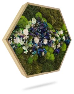 Een hexagonaal houten frame toont een levendige opstelling van groen mos, witte bloemen en blauwe bloemen. De opstelling heeft verschillende texturen en kleuren, wat een visueel aantrekkelijk patroon creëert. Het woord "BEMOSS" is aan de linkerkant van het frame afgedrukt.